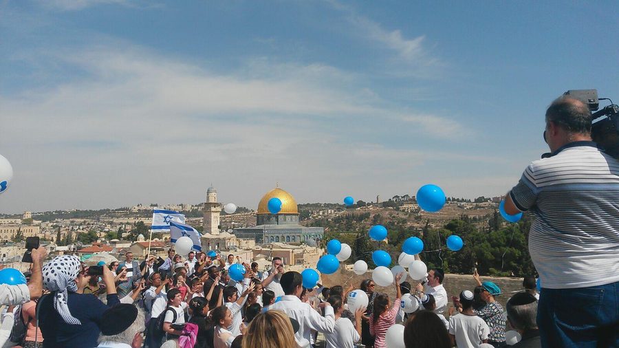 Blue and white balloons released over Jerusalem skyline with Dome of the Rock