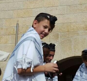 Smiling boy in talit at the Kotel ceremony