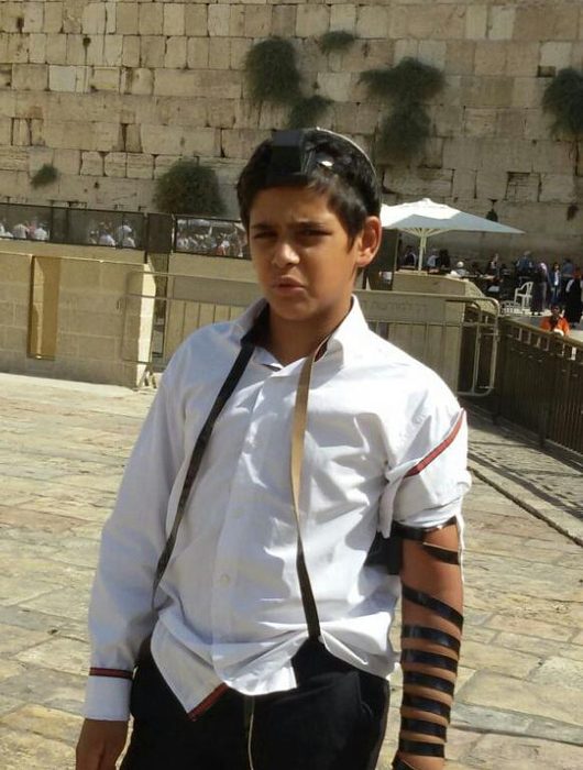 Bar Mitzvah boy wearing tefilin at the Western Wall