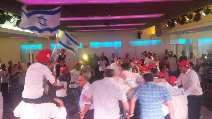 Joyous reception celebration with dancing children in red caps